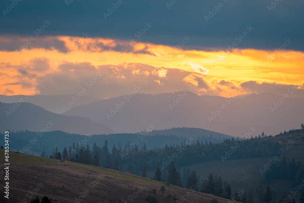 Carpathian mountain hills in the sunrise under the colorful cloudy sky.