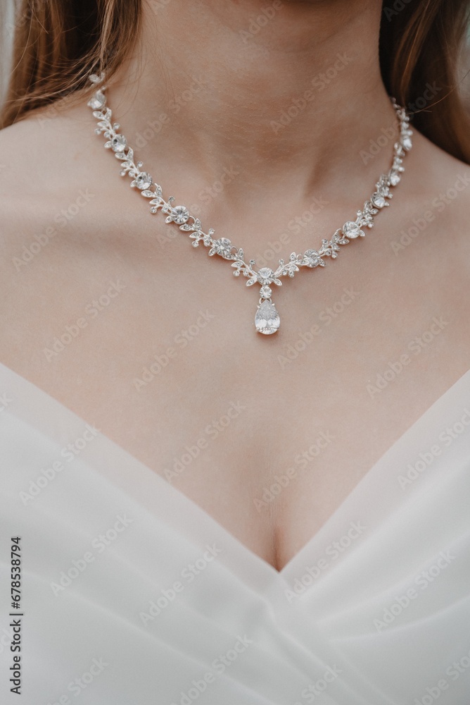 close-up of the necklace on the neck of the bride in a white dress