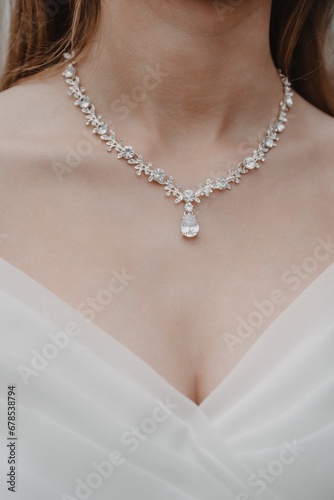 close-up of the necklace on the neck of the bride in a white dress