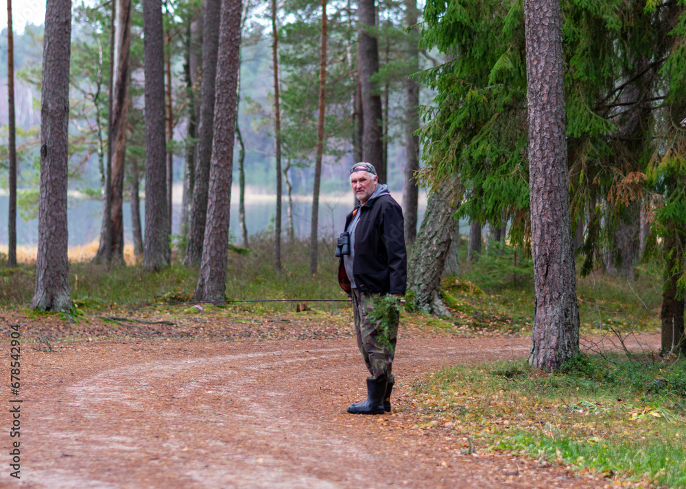 fisherman on the shore of a swamp lake, forest and swamp vegetation, rainy and cloudy day fisherman on the shore of a swamp lake, forest and swamp vegetation, rainy and cloudy day