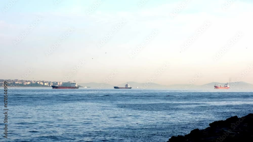 Several bulk carriers and tankers sail through the sea strait. Several bulk carriers and tankers sail through the sea strait.