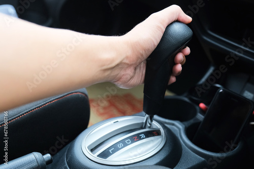 A car driver shifting the automatic transmission photo