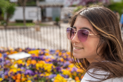 A happy young girl with a background of colorful flowers photo