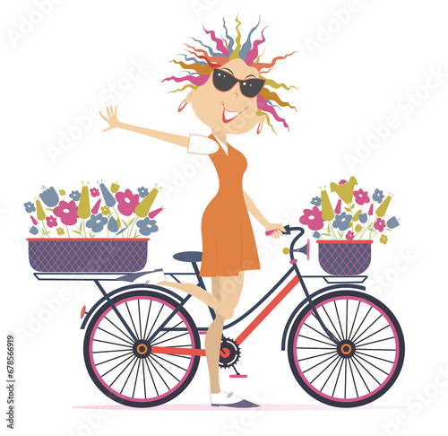 Pretty young cycling woman with bouquets of flowers in the baskets. Cycling woman carries bouquets of flowers in the baskets 