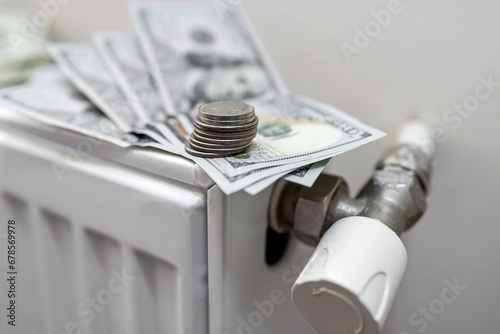 Radiator with dollar banknotes and coin cent as expensive heating cost