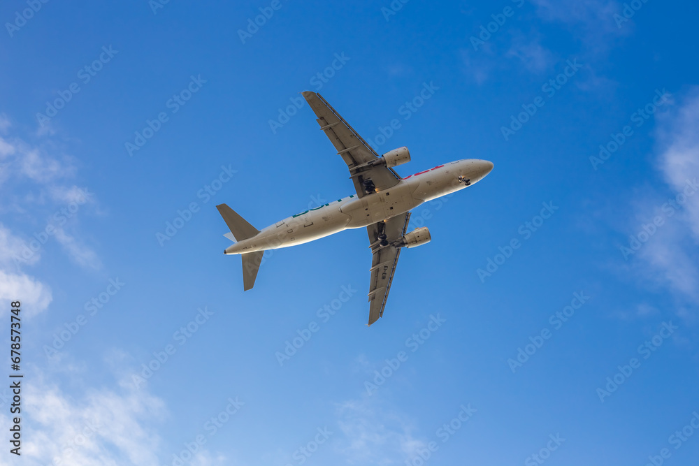 Passenger airplane. Low flying plane on the background of sky. Passenger Airplane Taking Off Into The Blue Sky. Linate Airport. Italia, Lombardia, San Donato Milanese Passenger airplane. Low flying plane on the background of sky. Passenger Airplane Taking Off Into The Blue Sky. Linate Airport. Italia, Lombardia, San Donato Milanese