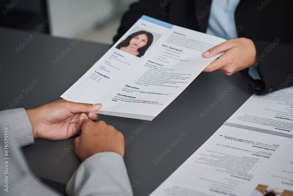 Close-up of young woman giving her documents to get visa while sitting at meeting with specialist in visa center Close-up of young woman giving her documents to get visa while sitting at meeting with specialist in visa center