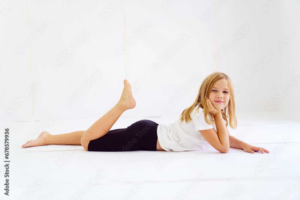 Cheerful teenage girl in white t-shirt and black breeches on white background Cheerful teenage girl in white t-shirt and black breeches on white background