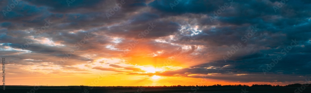 Panoramic View On Amazing Sunset Sunrise Morning Sky With Dark Rain Clouds. Morning Summer Time. Sunrise Sun Shining Through Clouds. Morning Summer Time. Sunrise Sun Shining Above Landscape.