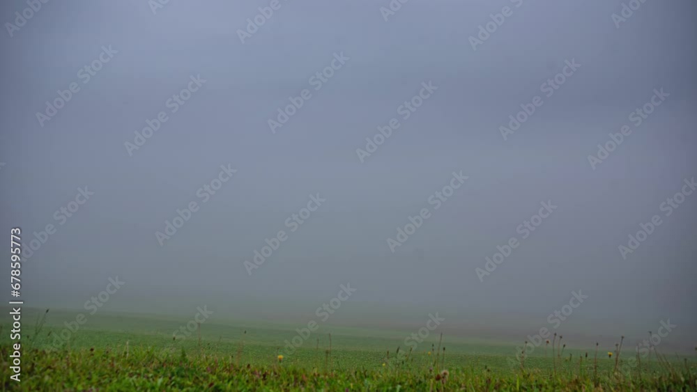 Low-lying fog fills a countryside valley below the mountains - time lapse