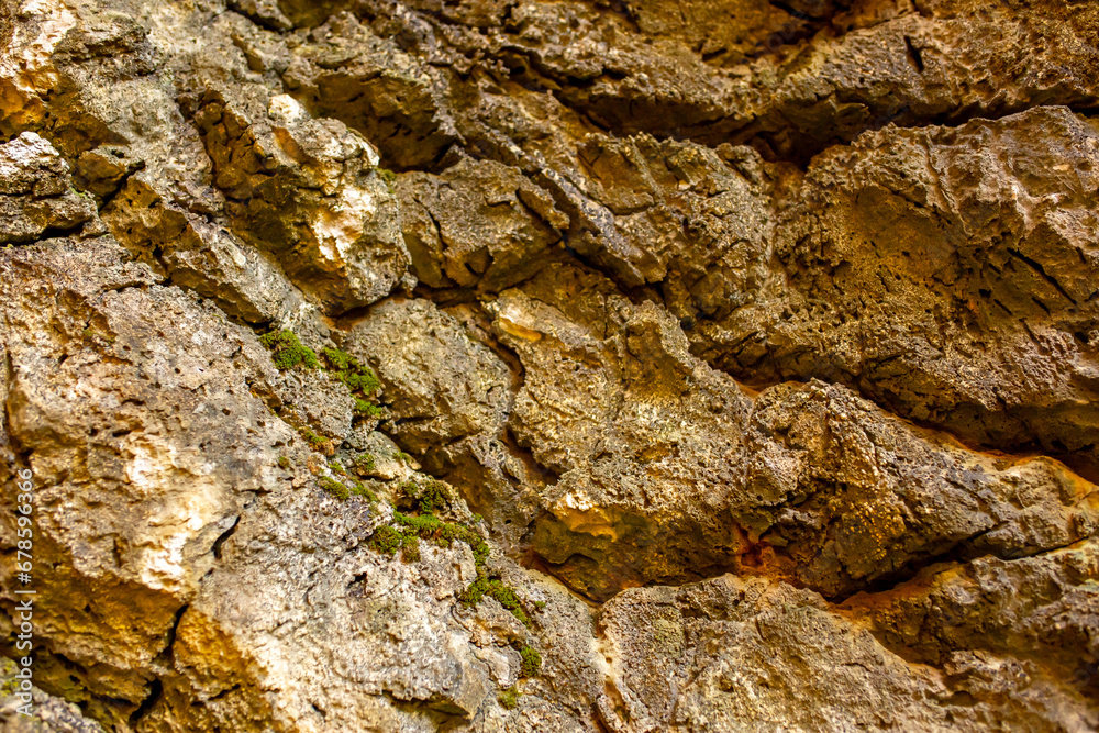 Natural rock texture background. Rocky bas-relief wall.