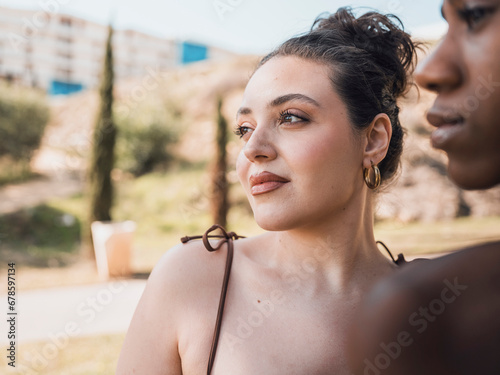 Contemplative woman with hair bun near friend photo