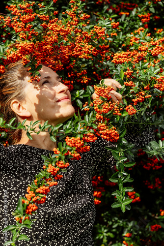 Happy woman touching sea buckthorn twig photo