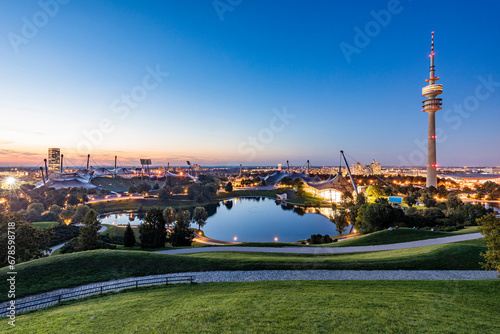 Germany, Bavaria, Munich, Olympic Park at dusk with Olympic Tower, BMW Building and pond in background photo