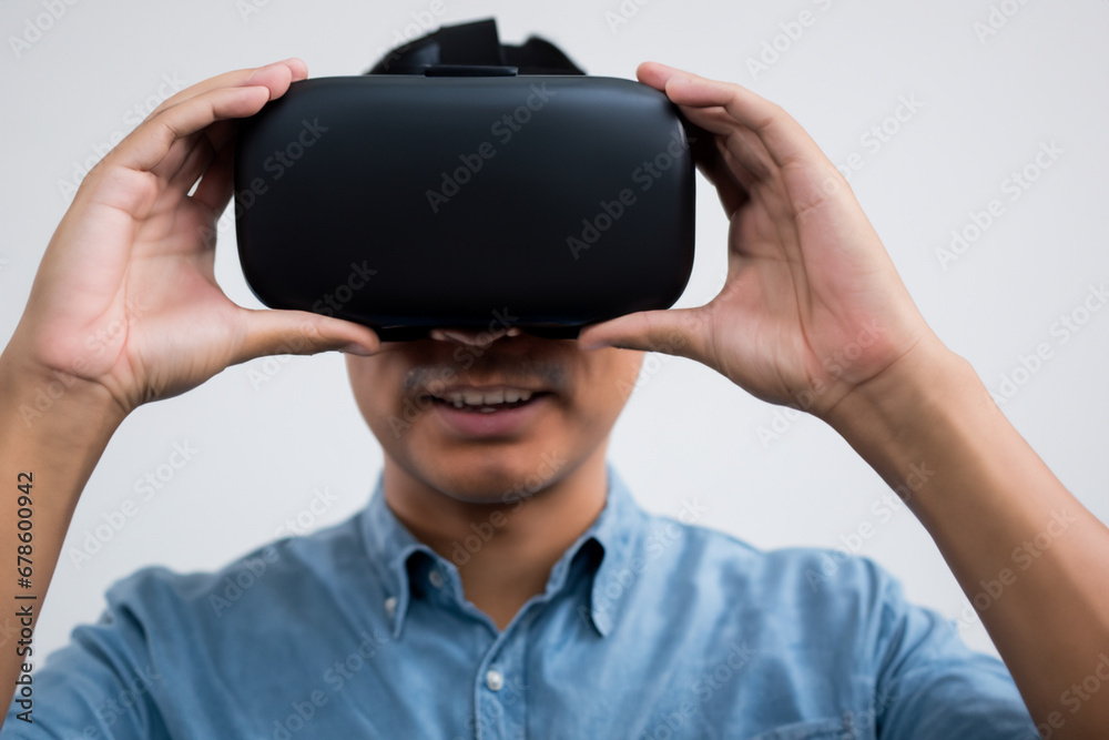 man wearing virtual reality goggles. a man in a shirt with a VR headset on his head, gray background. virtual reality concept man wearing virtual reality goggles. a man in a shirt with a VR headset on his head, gray background. virtual reality concept