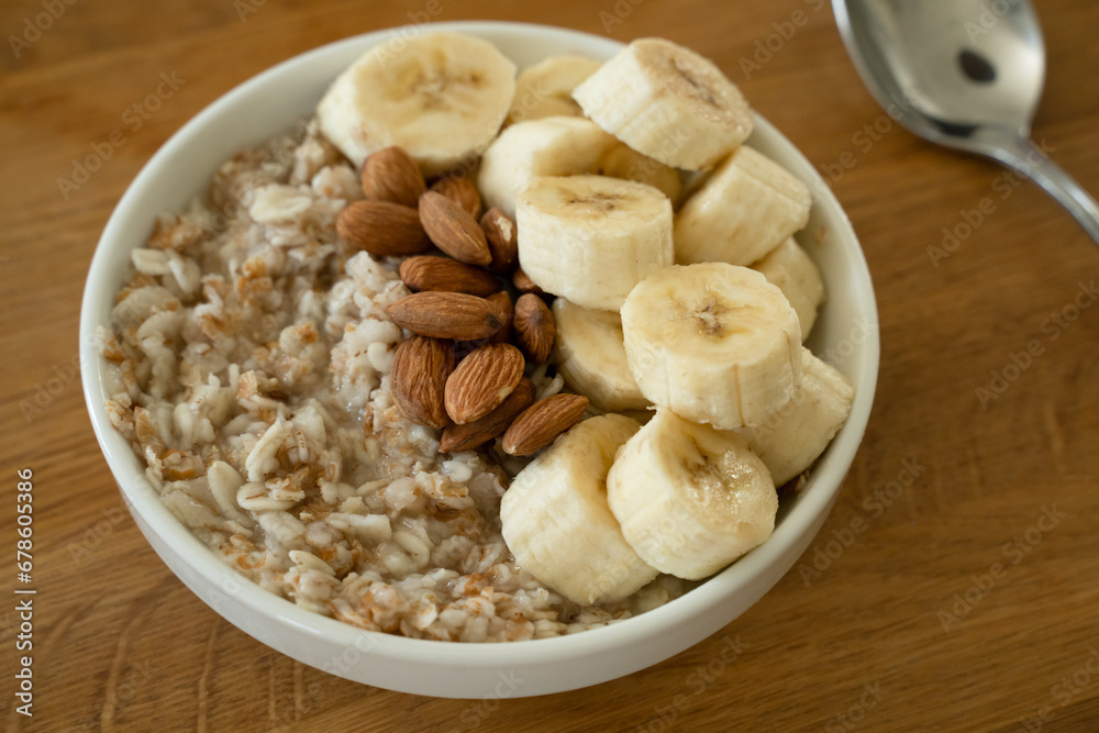 Oatmeal with banana, honey and almonda for breakfast on a table Oatmeal with banana, honey and almonda for breakfast on a table