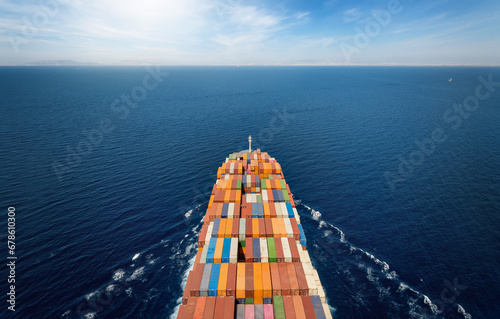 Fototapeta Naklejka Na Ścianę i Meble -  Aerial top view of a large, industrial container cargo ship sailing over the ocean with copy space