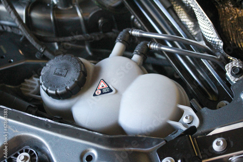 Abstract coolant reservoir in a new vehicle engine bay