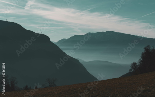 Panorama of the Dolomites on the Renon plateau. Foggy valleys. Dense haze between the mountains in winter. Bright sun and melted snow. Extensive landscape in the UNESCO national park.