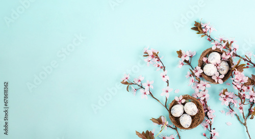 Photography Colored easter eggs in a bird nest, pink cherry blossoms, holiday greeting card,