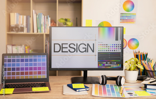 Graphic designer's workspace with a computer laptop and creative tools on the table