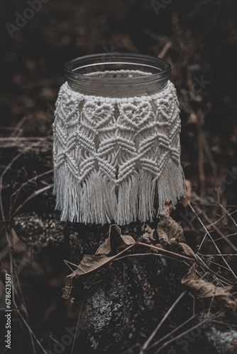 Jar with a burning candle decorated with knitted macrame fabric © AMBERLIGHT