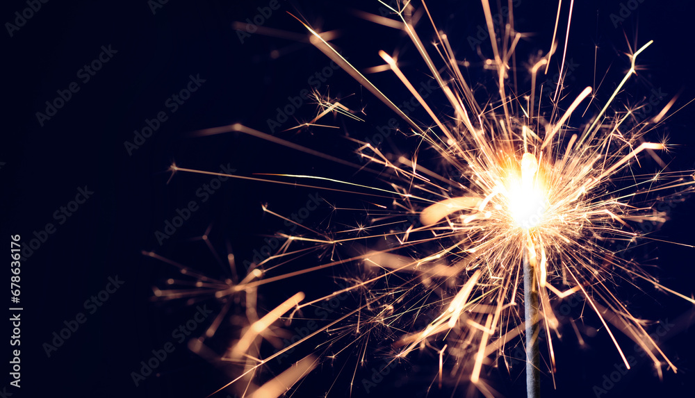 Burning sparkler on black background with copy space. New year party background. New year sparkles.