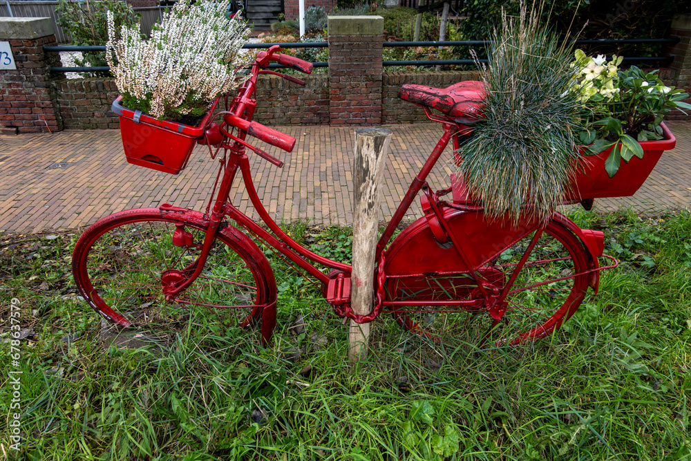 The Hague, Netherlands A bicycle painted red with flower pots stands on a street corner in the Scheveningen district. The Hague, Netherlands A bicycle painted red with flower pots stands on a street corner in the Scheveningen district.