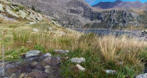 Beautiful landscape with a remote mountain lake.View of a stream that flows into Lake Gento, in the Aigüestortes National Park, on the Pyrenees of Catalonia,Spain.4k DCI resolution.Camera movement:Pan photo