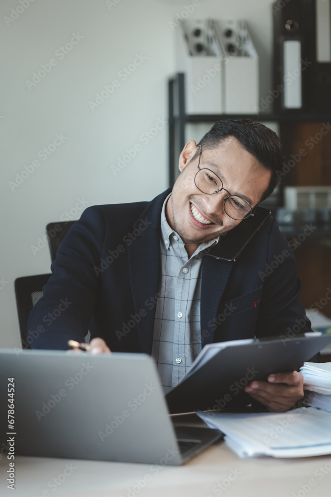 Businessman is sitting and working in the office, Employee is looking for information on laptop, An entrepreneur is talking on the phone with a company customer, startup. Businessman is sitting and working in the office, Employee is looking for information on laptop, An entrepreneur is talking on the phone with a company customer, startup.