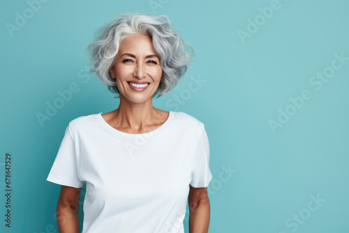 portrait of a smiling elderly woman with gray hair against blue background photo