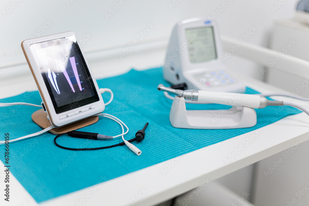 Photo of an apical locator on a dentist's table. Electronic instruments used in endodontics that measure the impedance, frequency, and resistance of the surrounding material.