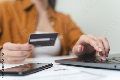 Hands of person entering credit card data laptop computer during pay for internet shopping online at home.