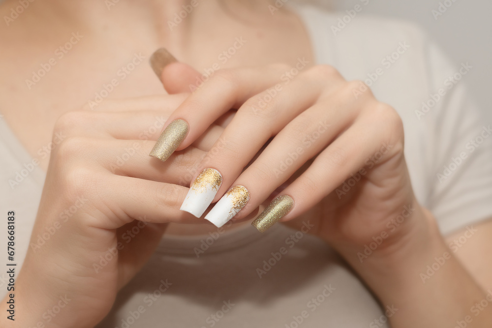 Female hands with long nails with glitter nail polish. Long gold nail design. Women hands with sparkle manicure. Female hands with long nails with glitter nail polish. Long gold nail design. Women hands with sparkle manicure.