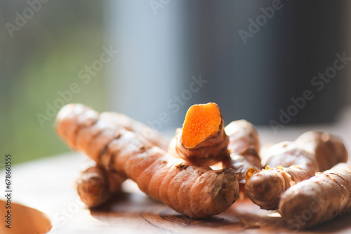 Fresh turmeric roots on a green leaf, close up.