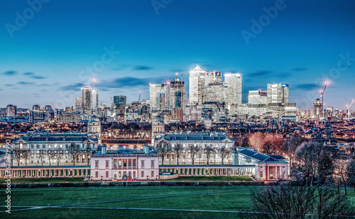 panoramic view from Greenwich on Canary Wharf financial district with skyscrapers at night. View includes the park, National Maritime Museum, Royal chapel and O2