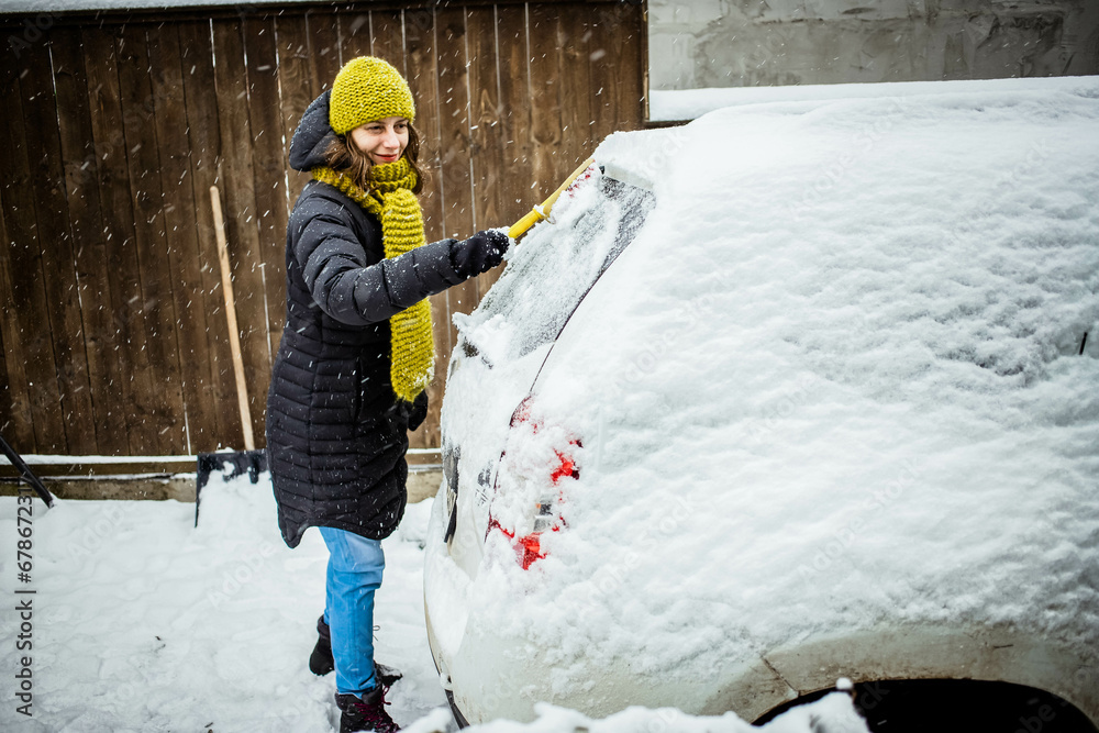 woman cleaning snow from car after blizzard woman cleaning snow from car after blizzard