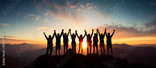 Group of team cheering on top of the mountain. Team work concept photo