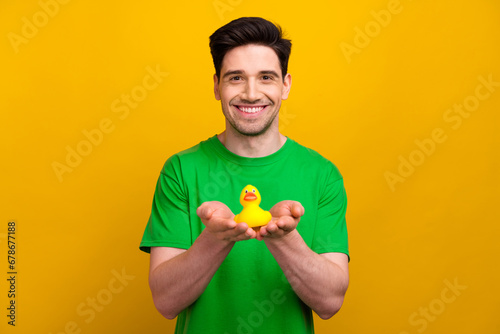 Obraz na plátně Photo portrait of attractive young brunet man hands hold rubber duck bath wear t
