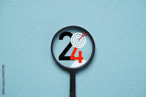 2024 year with dartboard inside of magnifier glass for focusing in objective target include business , life , health , family concept.