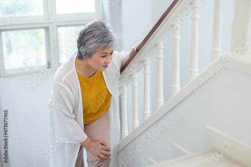 Konstfotografi Asian elderly woman walking up stairs have pain knee ache in house