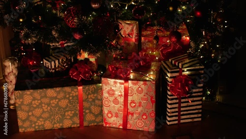 Christmas gift under decorated with light christmas tree in dark room in warm colors. High quality 4k footage