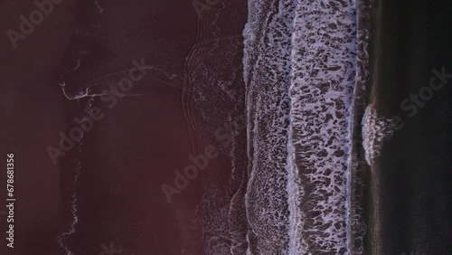 Abstract birds eye foamy ocean waves breaks on beach in sunset. High quality 4k aerial top down footage