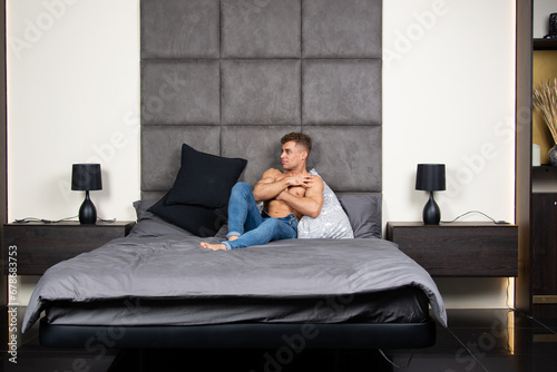 A young attractive man with a beautiful body is resting at home.