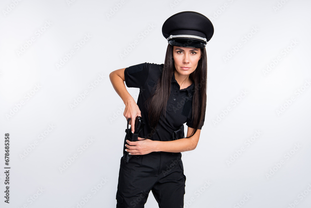 Photo of cute serious young policewoman dressed black clothes headwear ready for gun shot isolated white color background Photo of cute serious young policewoman dressed black clothes headwear ready for gun shot isolated white color background