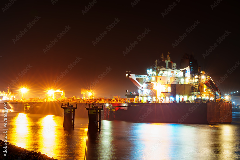 Majestic view of the Rotterdam port at night, shrouded in mist with the city lights illuminating the surroundings, creating a captivating and atmospheric scene.