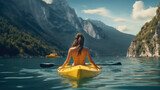 Young woman kayaking on lake in mountains. Rear view. Concept of active lifestyle.
