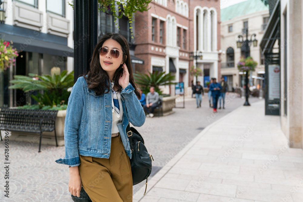 Fototapeta premium taiwanese girl leaning on a pole enjoying afternoon leisure time in California