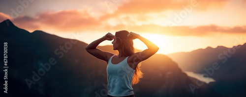 Independent woman flexing her arms outdoor in front of majestic sunset