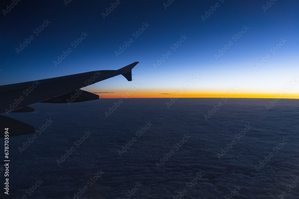 View from an airplane at dawn, photo in low light. Airplane wing view from the window. View from an airplane at dawn, photo in low light. Airplane wing view from the window.